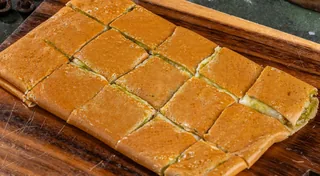 Pesto Melt: Tonino crepe cut into bite-sized squares on a wooden board