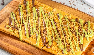 Dubai Chocolate: Tonino dessert with toppings served on a wooden board