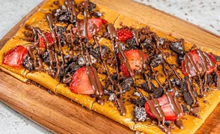 Hazelnut Crunch: Tonino dessert with toppings served on a wooden board