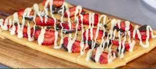 Royal Crush: Tonino dessert with toppings served on a wooden board
